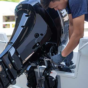 Davidson Marine Mechanic Doing A Boat Repair On An Outboard Motor